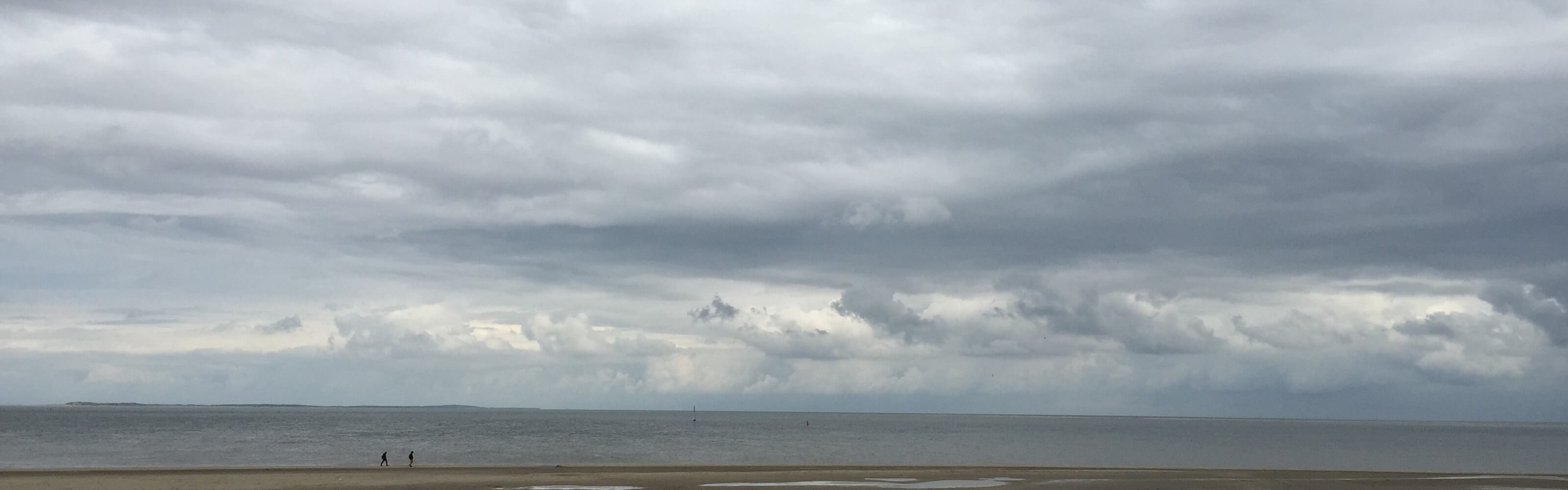 Een licht bewolkte lucht aan zee